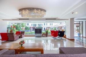 曼谷Lasalle Suites Hotel & Residence的客厅配有红色椅子和吊灯。