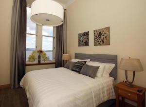 巴洛赫4 Lomond Castle的卧室配有白色的床和窗户