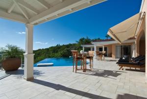泰尔斯贝斯Dream Villa Terres Basses 543的一个带桌椅的庭院和一个游泳池