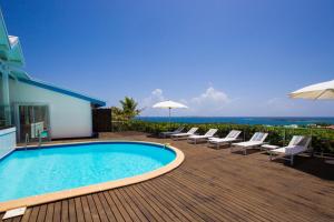 东方湾Dream Villa Orient Bay 570的游泳池位于带椅子和遮阳伞的甲板上