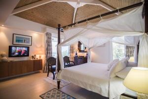 东方湾Dream Villa Orient Bay 570的一间卧室设有一张天蓬床和一台电视机。