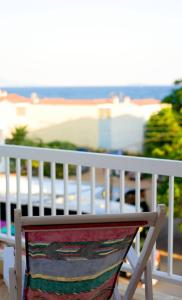 梅塔诺佛希斯Sun的一张白色长椅,坐在一个背靠大海的阳台