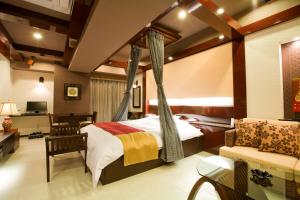 神户Hotel Bintang Pari Resort (Adult Only)的一间卧室配有天蓬床和沙发