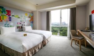 台北丹迪旅店大安森林公园店的酒店客房设有两张床、一张书桌和一个窗户。