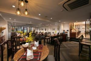 河内Hong Ngoc Dynastie Boutique Hotel & Spa的一间在房间内配有桌椅的餐厅