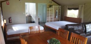 谭伯连山Southern Sky Glamping的客房设有两张床、一张桌子和一张沙发。