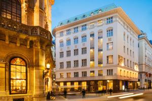 维也纳维也纳风格丽笙酒店的一座白色的大建筑,人们在街上散步