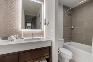 夏洛特欧尼夏洛特酒店的一间带水槽、卫生间和镜子的浴室