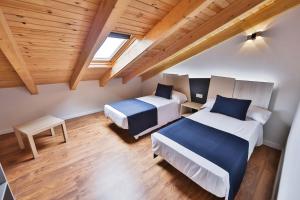 卡马里尼亚斯Apartamentos Playa de Camariñas的配有木天花板的客房设有两张床。