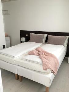 阿科La Casa di Giò的一张白色大床,上面有粉红色的毛巾