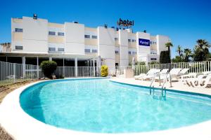 拉加尔德Kyriad Toulon Est Hyeres La Garde的酒店前的游泳池