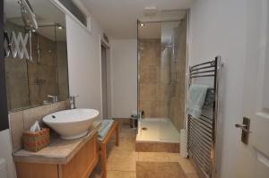 利明顿温泉The Coach House Studio Apartment的浴室配有白色水槽和淋浴。