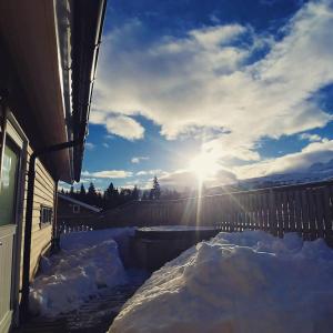 阿克雷里Hotel Kjarnalundur- Aurora Dream - Lodges and Rooms的天空中阳光下积雪覆盖的院子