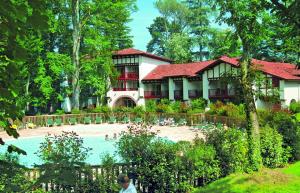 圣让皮耶德波尔Residence Parc Arradoy的一座带游泳池的度假村,位于一座建筑前