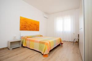 莱韦拉诺Borgo di Leverano, apartment 02的卧室配有一张床,墙上挂有绘画作品