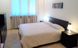 皮特拉利古Appartamento Angela的卧室配有白色的床和电视。