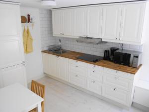 隆德隆德联排别墅公寓的厨房配有白色橱柜和微波炉