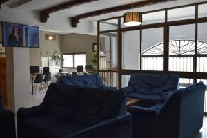阿瓜杜尔塞Hostales Juan de Austria I & II的客厅配有蓝色的沙发和桌子