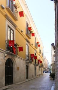 比通托Palazzo Antica Via Appia的挂在街上阳台的红旗建筑