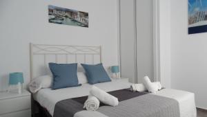 科尼尔-德拉弗龙特拉apartamento rio salado的一间卧室配有一张带蓝白色枕头的大床