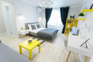 苏梅Apart-Hotel "LAVINA"的一间卧室配有一张床和一张黄色的桌子
