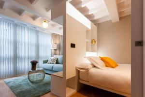 拉科鲁尼亚APARTAMENTOS FRANJA 55的一间卧室配有一张床和一张蓝色的沙发