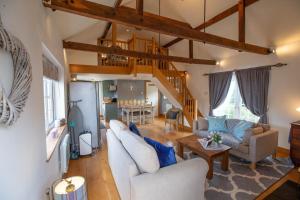 巴斯樱桃园山林小屋的客厅配有白色家具和木制天花板。