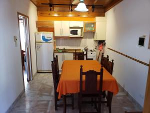 罗萨里奥Complejo La Naranjita的厨房配有桌子和白色冰箱。