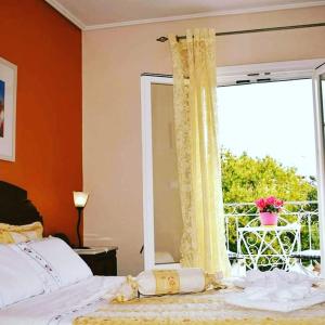 加拉希德松Mira Mare Hotel, Galaxidi的一间卧室设有一张床和一个阳台的窗户。