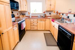 塔尔基特纳Talkeetna Hideaway的厨房配有木制橱柜和黑色洗碗机。