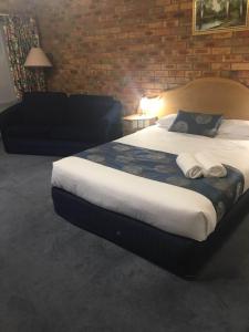 谢珀顿松树乡村俱乐部汽车旅馆的砖墙客房内的一张大床