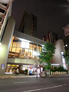 埼玉市浦和华盛顿酒店的一座建筑,在晚上有人在建筑前面行走