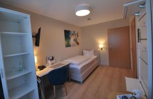 赖因伯伦斗兽场旅馆的小房间,配有床和书桌