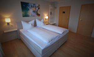 赖因伯伦斗兽场旅馆的卧室配有白色的床单和枕头