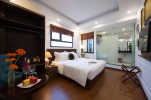 河内Hanoi Amber Hotel的一间卧室配有一张床和一张桌子及一碗水果