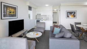 布里斯班Oaks Brisbane on Margaret Suites的带沙发、电视和桌子的客厅
