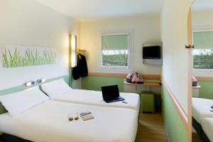 阿利坎特ibis budget Alicante的酒店客房,配有一张带笔记本电脑的床