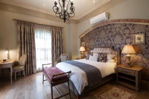 弗里尼欣Three Rivers Lodge and Villas的一间卧室配有一张大床和一个吊灯。