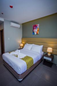 独鲁万Hotel Costa Brava的一间卧室配有一张大床和两盏灯。
