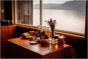 因弗莫里斯顿Loch Ness Lochside Hostel, Over 16s Only的一张桌子,上面放着一盘食物,还有一个窗口