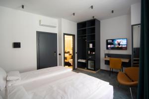 锡比乌Kleines Hotel的一间卧室配有一张床、一张书桌和一台电视