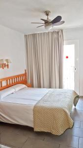 布拉内斯伊莎贝尔旅馆的一间卧室配有一张带吊扇的床