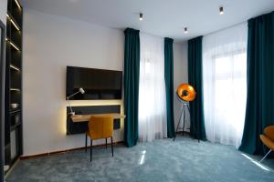锡比乌Kleines Hotel的客房设有书桌和带电视的桌子。