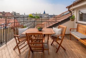 布拉格City Nest Apartments by Adrez的阳台上的木桌和椅子