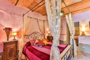 佩尔吉内-瓦尔达诺La Miccia的一间卧室设有天蓬床和木制天花板