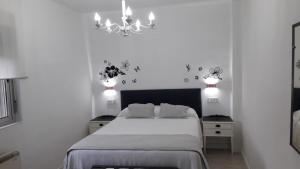 罗德里戈城VuT San Blas的白色卧室配有一张床和一个吊灯