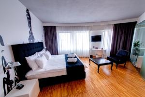 布加勒斯特萨洛里亚酒店的一间卧室配有一张床、一把椅子和一张沙发