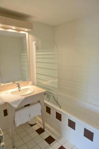MontagnieuHotel Restaurant Rolland的浴室配有水槽、淋浴和浴缸。