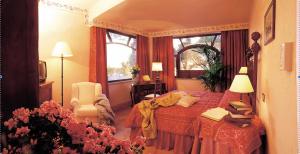 格罗塔费拉塔拉洛坎达戴切卡酒店的卧室配有床、椅子和窗户。