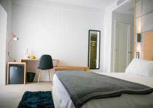 Hinojosa del DuqueHotel EH Piedra Y Luz的一间卧室配有一张床、一张桌子和一把椅子